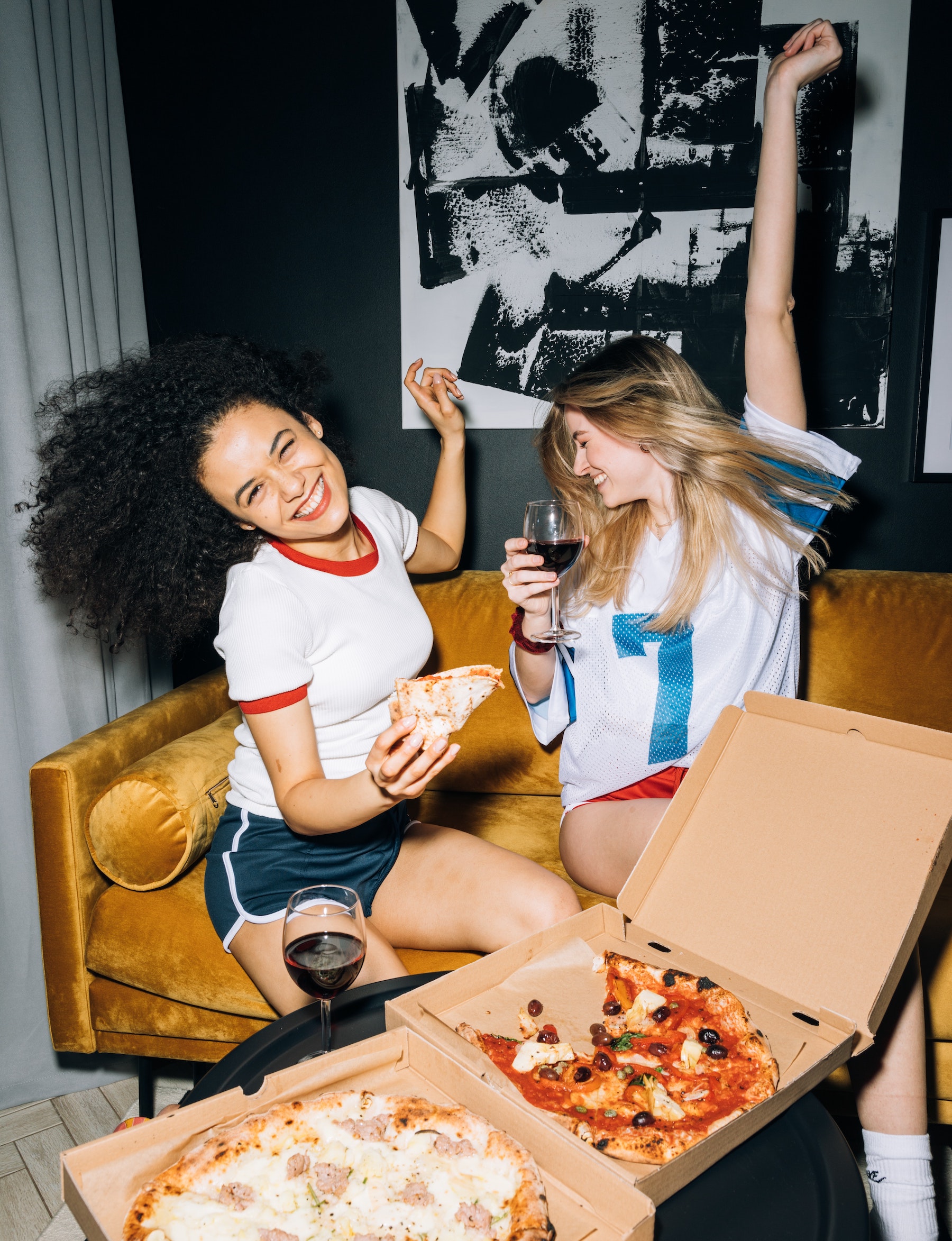 two girls having wine and pizza